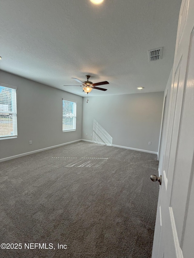 unfurnished room with ceiling fan, carpet, and a textured ceiling