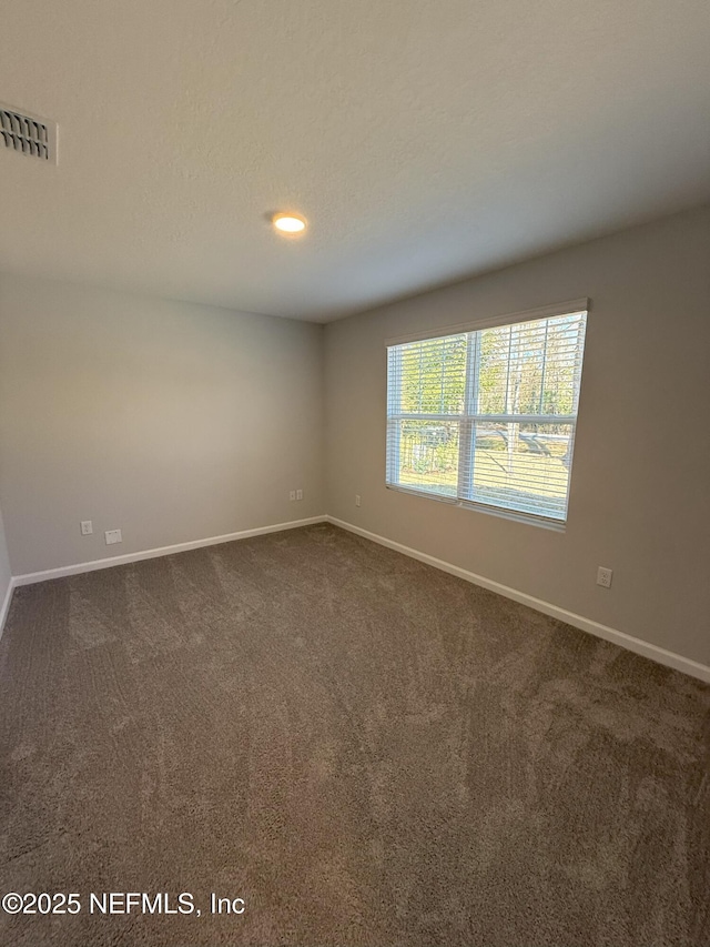 carpeted empty room with a textured ceiling