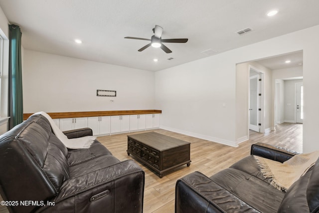 living room with light hardwood / wood-style floors and ceiling fan