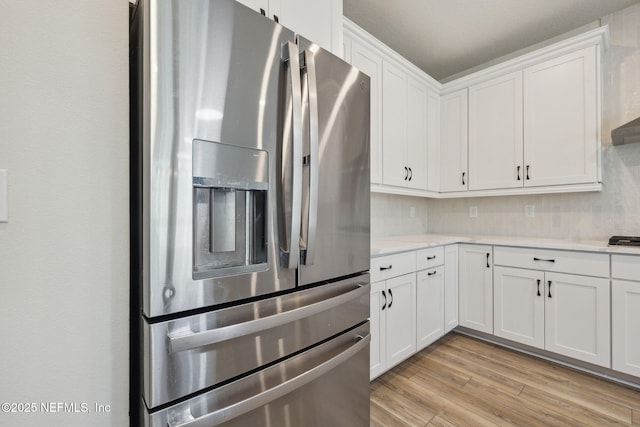 kitchen featuring stainless steel fridge with ice dispenser and white cabinets