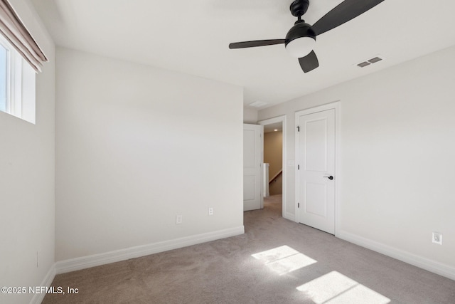 empty room with light colored carpet and ceiling fan