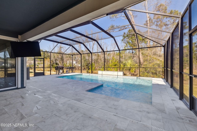 view of swimming pool featuring a patio and glass enclosure