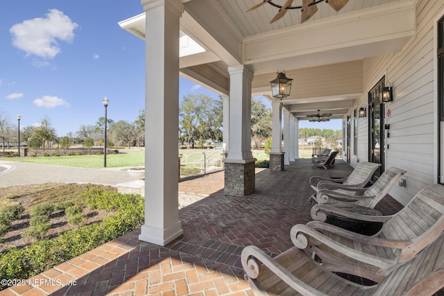 view of patio with ceiling fan and a porch