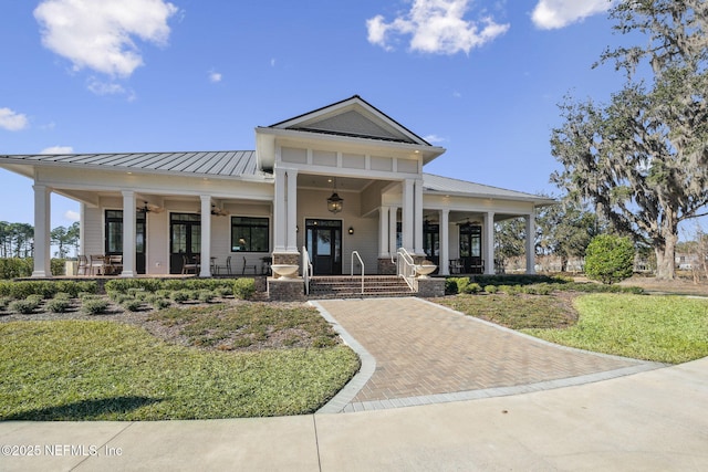 neoclassical home featuring ceiling fan, a porch, and a front lawn