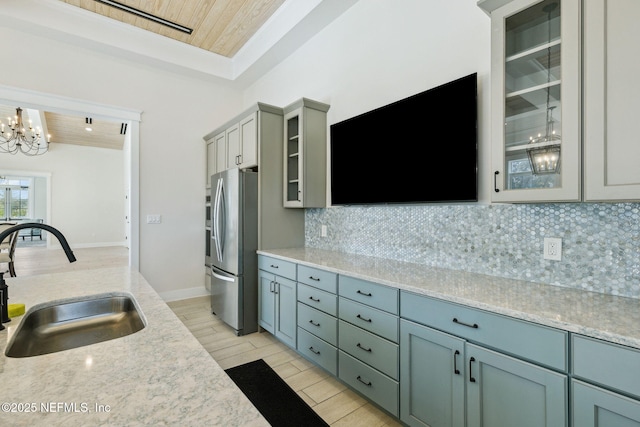 kitchen featuring stainless steel refrigerator, sink, decorative backsplash, wood ceiling, and light wood-type flooring