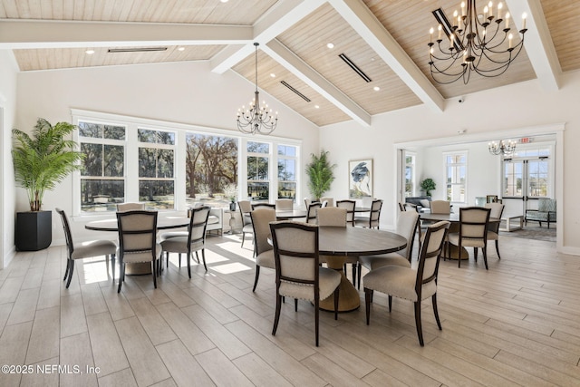 dining area with beamed ceiling, a chandelier, high vaulted ceiling, and light hardwood / wood-style flooring