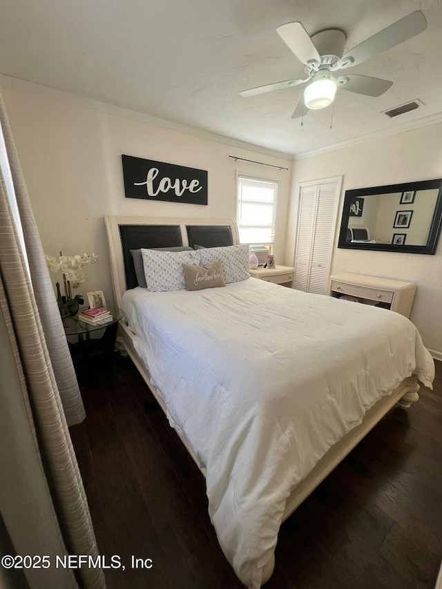 bedroom with dark wood-type flooring, ceiling fan, ornamental molding, and a closet