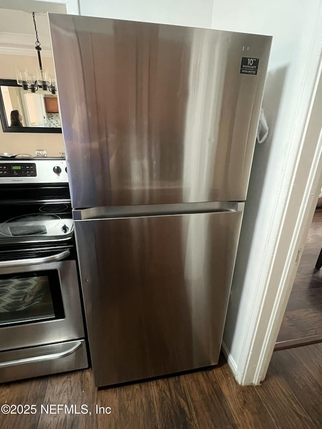 kitchen featuring crown molding, stainless steel appliances, and dark hardwood / wood-style flooring