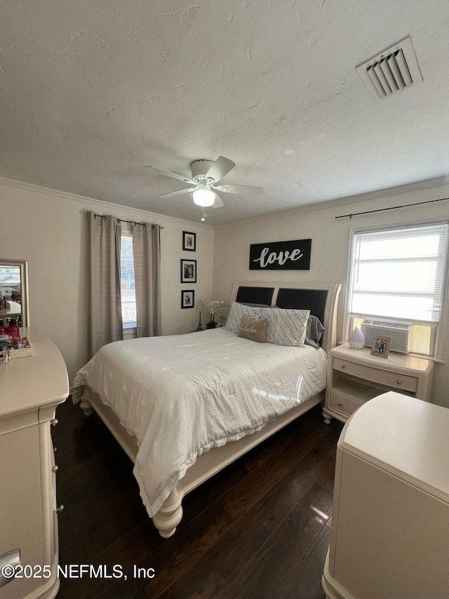 bedroom with ceiling fan, dark hardwood / wood-style floors, and a textured ceiling