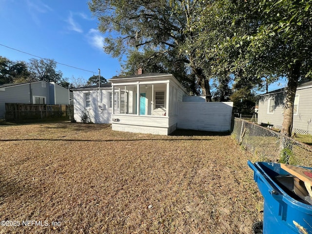 rear view of house featuring a sunroom