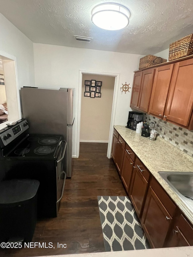 kitchen with sink, tasteful backsplash, stainless steel electric range, a textured ceiling, and dark hardwood / wood-style floors