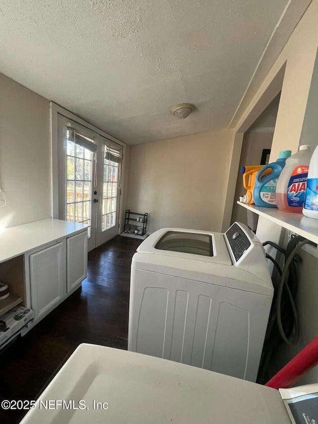 clothes washing area with french doors, washing machine and clothes dryer, dark hardwood / wood-style floors, and a textured ceiling