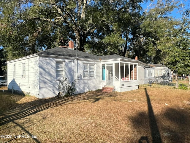 view of front of property with a sunroom and a front yard