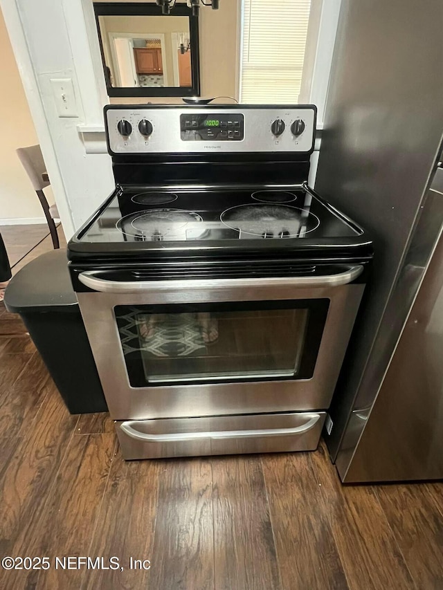 interior details with dark wood-type flooring and appliances with stainless steel finishes