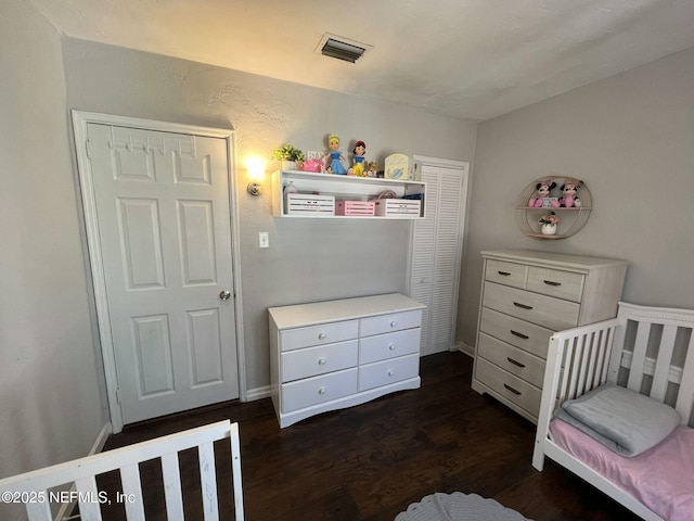 bedroom with dark hardwood / wood-style floors