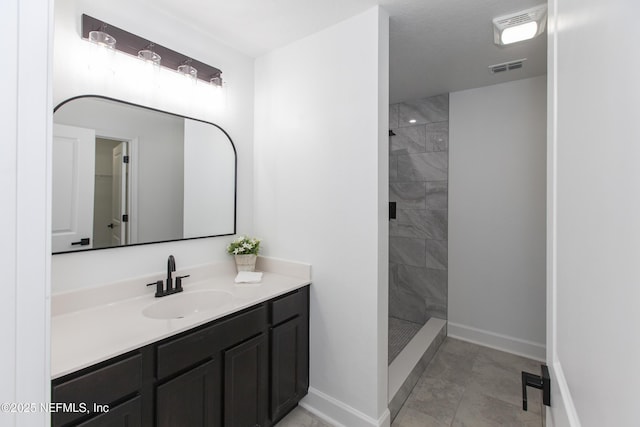 bathroom featuring a tile shower and vanity