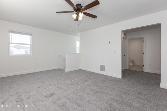 empty room with light carpet, a wealth of natural light, and ceiling fan