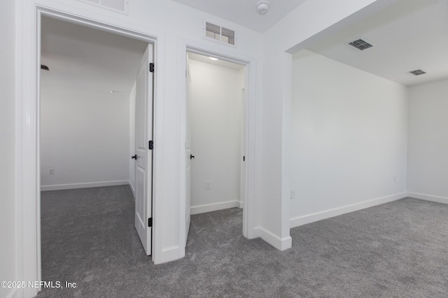 corridor featuring dark colored carpet