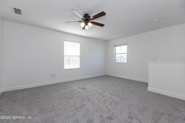 unfurnished room with carpet floors, a wealth of natural light, and ceiling fan