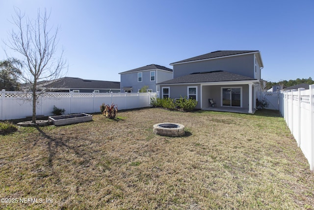 back of property featuring a yard and a fire pit