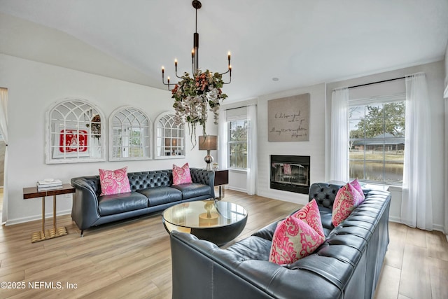 living room with light hardwood / wood-style flooring, a wealth of natural light, and vaulted ceiling