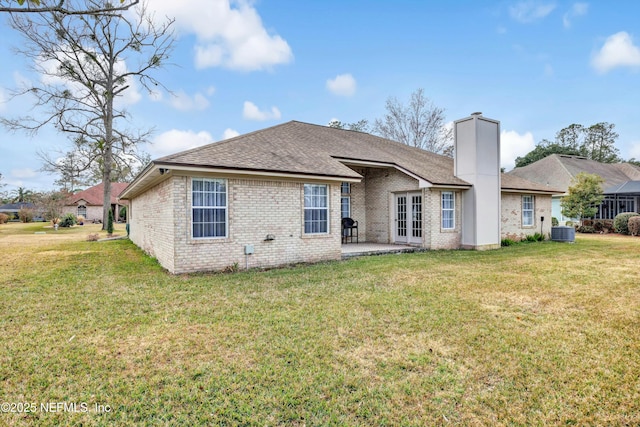 rear view of house featuring central AC unit, a lawn, and a patio area