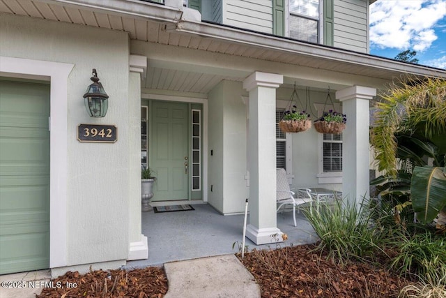 property entrance with a garage and covered porch