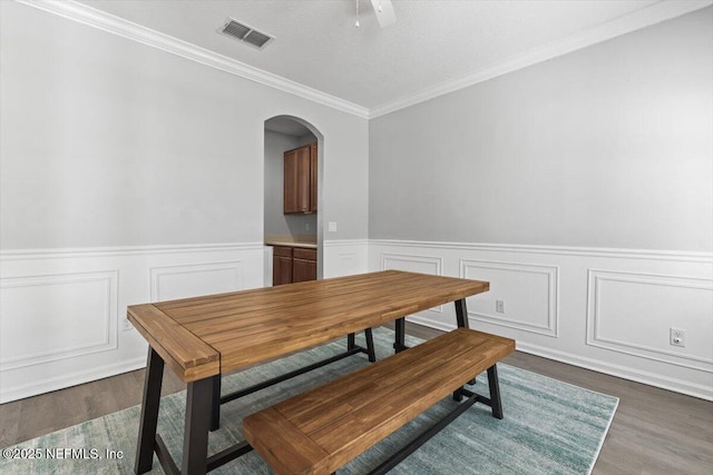 dining room with ornamental molding and dark hardwood / wood-style flooring