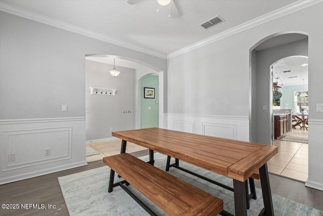 dining space featuring ceiling fan, ornamental molding, and wood-type flooring