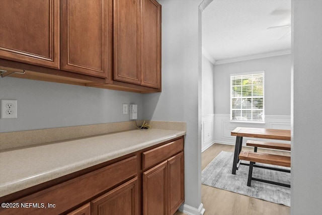 kitchen with crown molding and light hardwood / wood-style floors