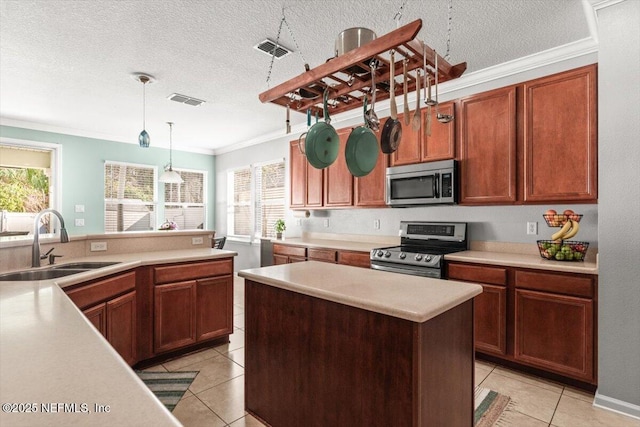 kitchen featuring sink, a center island, hanging light fixtures, ornamental molding, and stainless steel appliances