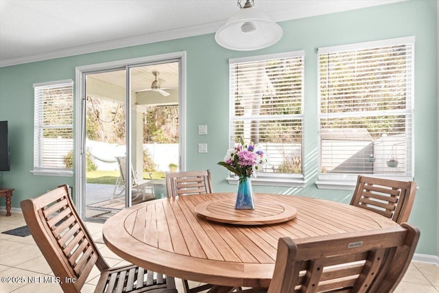 tiled dining space with ornamental molding and ceiling fan