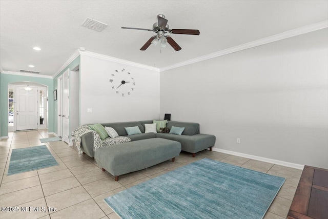 living room featuring crown molding, light tile patterned floors, ceiling fan, and a textured ceiling