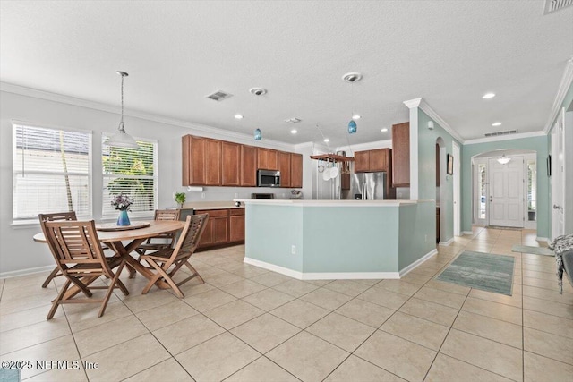 kitchen with light tile patterned flooring, appliances with stainless steel finishes, decorative light fixtures, and a textured ceiling