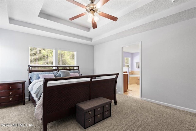 bedroom featuring multiple windows, a tray ceiling, light colored carpet, and a textured ceiling