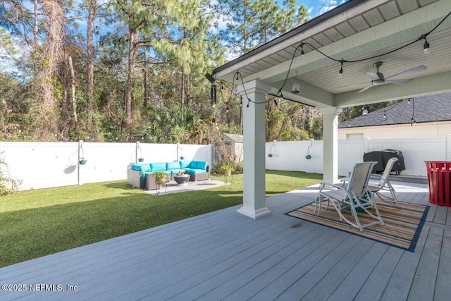 wooden terrace with a yard, outdoor lounge area, and ceiling fan