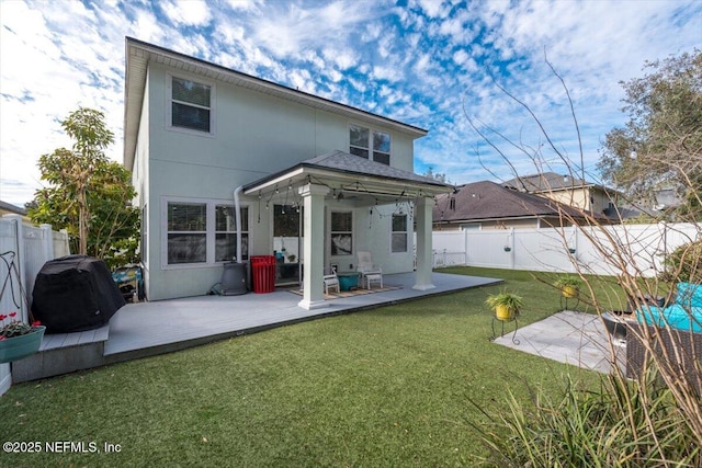 rear view of house featuring a patio and a lawn