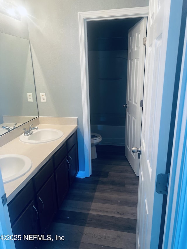 full bathroom with vanity, bathtub / shower combination, hardwood / wood-style floors, and toilet