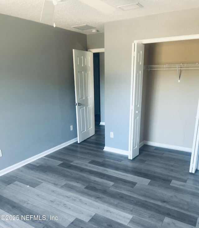 unfurnished bedroom with dark hardwood / wood-style flooring, a closet, and a textured ceiling