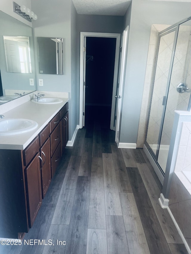 bathroom featuring hardwood / wood-style flooring, vanity, and walk in shower