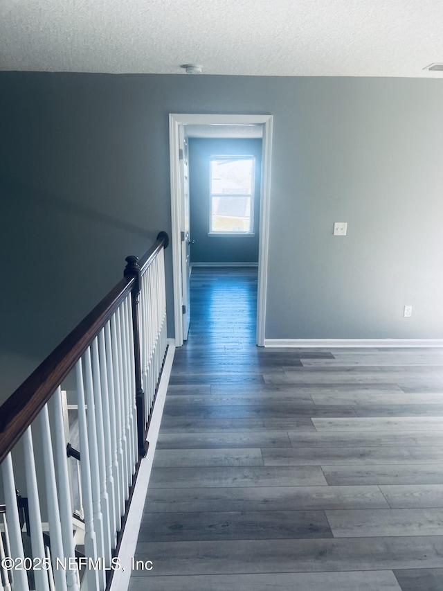 hallway featuring dark hardwood / wood-style floors and a textured ceiling