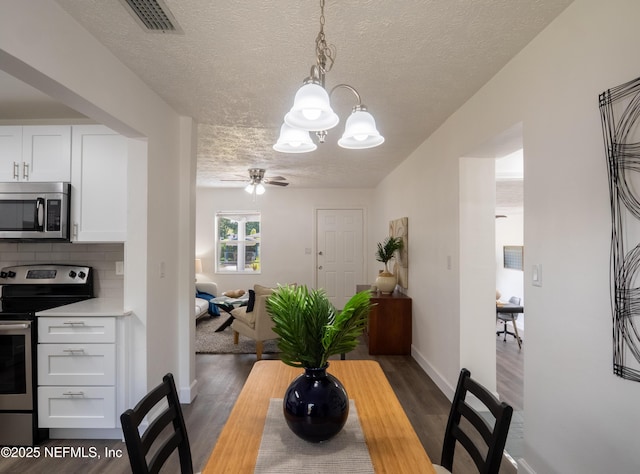 dining room with a chandelier, a textured ceiling, and dark hardwood / wood-style flooring