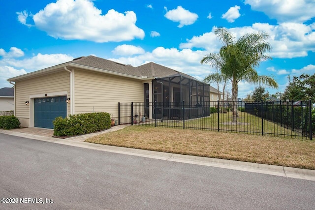 exterior space featuring a garage, a lanai, and a front yard