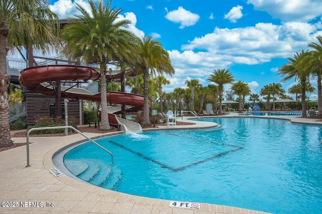 view of swimming pool featuring a water slide and a patio area