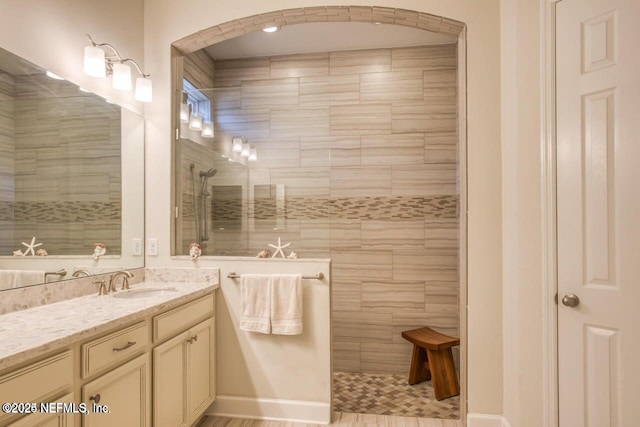 bathroom with vanity and a tile shower