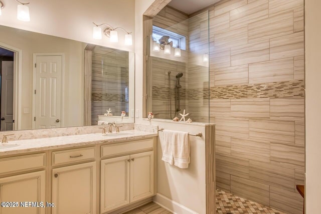 bathroom with a tile shower and vanity