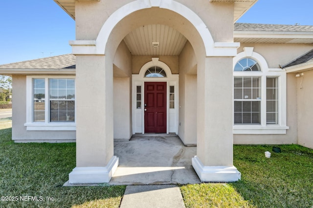 view of exterior entry with a lawn