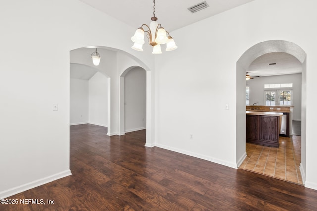 unfurnished room featuring sink, dark hardwood / wood-style floors, and ceiling fan with notable chandelier