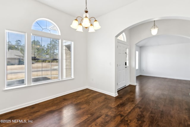 unfurnished dining area with dark hardwood / wood-style flooring and a notable chandelier