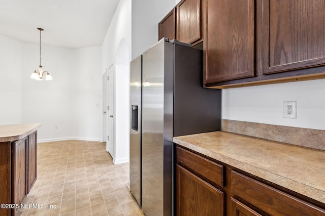 kitchen featuring stainless steel refrigerator with ice dispenser, pendant lighting, and a chandelier